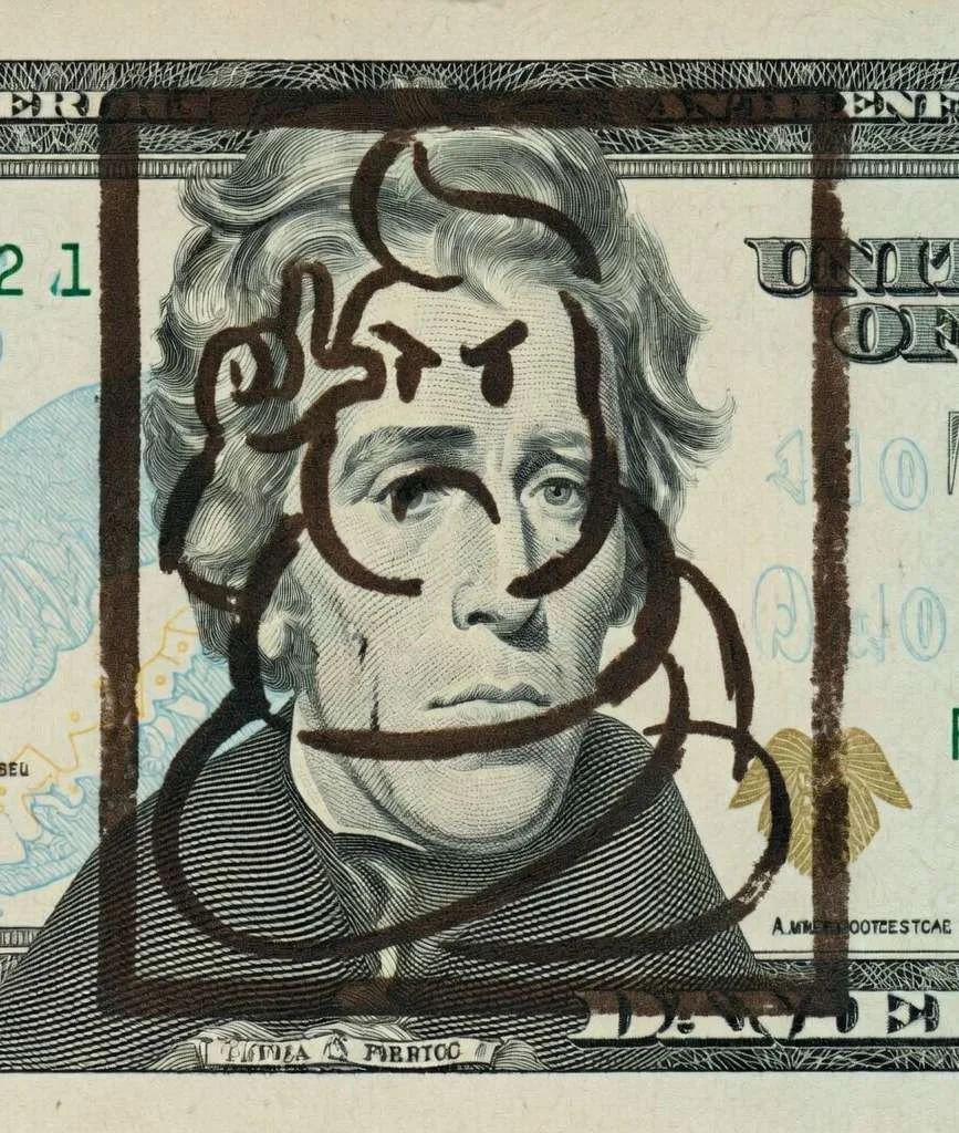 Close-up of a $20 bill stamped with a turd-Trump rubber stamp design over Andrew Jackson